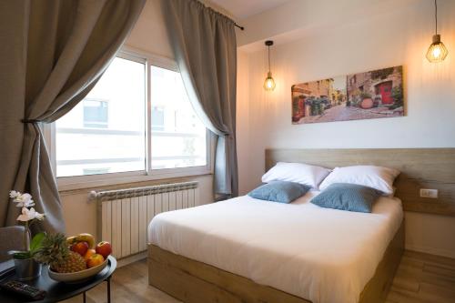 a bedroom with a bed with a window and a bowl of fruit at Aju Hillel 14 in Jerusalem