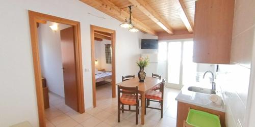 a kitchen and dining room with a table and a sink at Stella Maris Marzamemi Apartments in Marzamemi