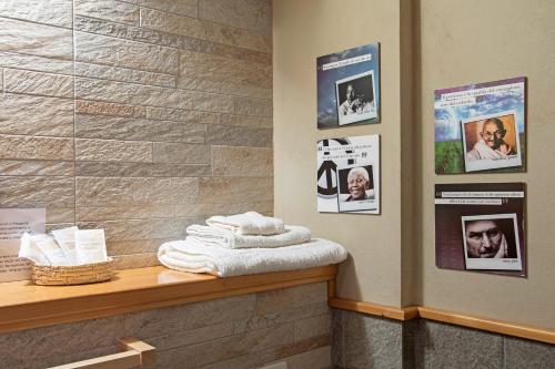 una stanza con bancone, asciugamani e foto appese al muro di B&B Del Centro a Clusone