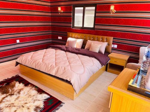 a bedroom with a bed in a room with red walls at Rum Magic Nights in Wadi Rum