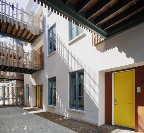 a building with a yellow door in a courtyard at The Iris in Charleston