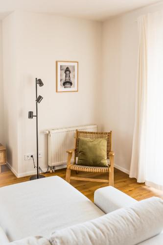 a bedroom with a bed and a chair and a window at Wunderschöne Ferienwohnung mit Feldblick und Balkon, mit kostenlosem Wlan und Strandfahrrad, Haustiere erlaubt in Börgerende-Rethwisch