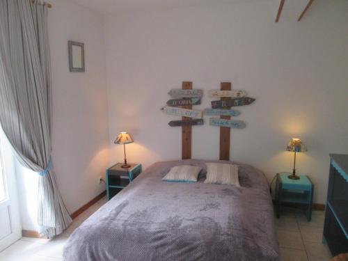 a bedroom with a bed with signs on the wall at Les Lutins for 4 persons. near the sea. in Commes