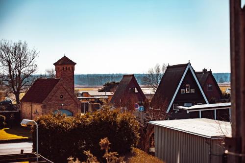 a group of houses and a church with a tower at Wunderschöne Ferienwohnung mit Feldblick und Balkon, mit kostenlosem Wlan und Strandfahrrad, Haustiere erlaubt in Börgerende-Rethwisch