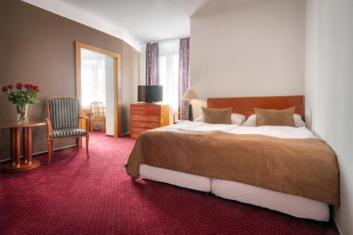 a hotel room with a bed and a chair at Hotel Harmony in Prague