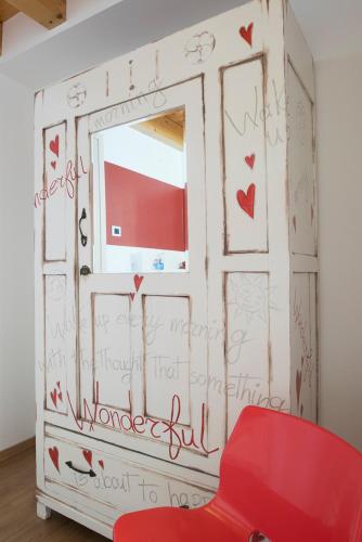 a room with a window and a red chair at B&B Del Centro in Clusone
