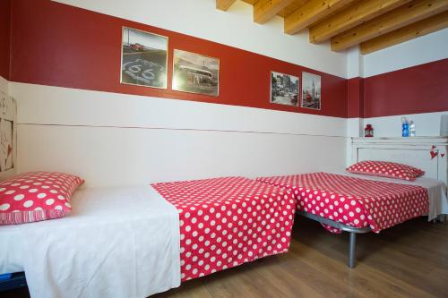 a bedroom with two beds with red and white polka dots at B&B Del Centro in Clusone