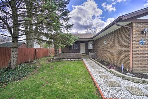 a brick house with a fence and a yard at Delightful Tipp City Unit with Covered Patio! in Tipp City