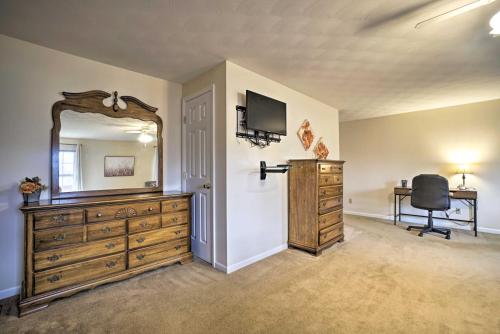 a bedroom with a dresser and a mirror and a chair at Delightful Tipp City Unit with Covered Patio! in Tipp City