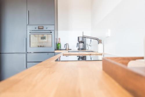a kitchen with a wooden counter top and a sink at Wunderschöne Ferienwohnung mit Feldblick und Balkon, mit kostenlosem Wlan und Strandfahrrad, Haustiere erlaubt in Börgerende-Rethwisch