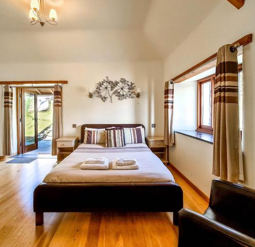 een slaapkamer met een bed met twee handdoeken erop bij Ta Mill Cottages & Lodges - Olde Granary in Launceston