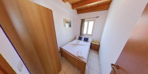 a small bathroom with a bed and a window at Stella Maris Marzamemi Apartments in Marzamemi