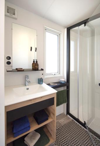 une salle de bain avec un lavabo et une douche dans l'établissement Camping De La Plage Bénodet - 400 mètres de La Plage, à Bénodet