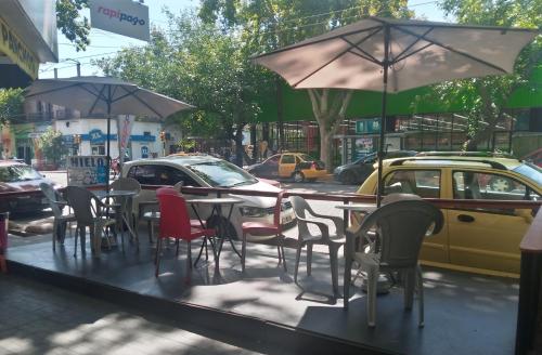 ein Tisch mit Stühlen und einem Sonnenschirm auf einer Straße in der Unterkunft Departamentos Avenida San Martin in Mendoza
