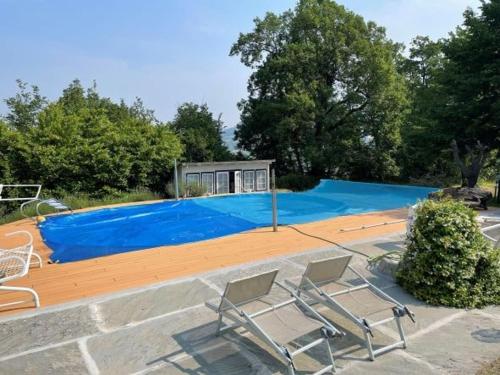 einen Pool mit zwei Liegestühlen davor in der Unterkunft “SPArisio” CASA IN SASSO CON PISCINA E CAMPO DA TENNIS in Lama