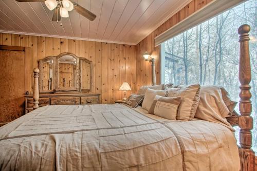 a bedroom with a large bed with a large window at Cozy Home with Hot Tub Half Mi to Salmon River! in Salmon