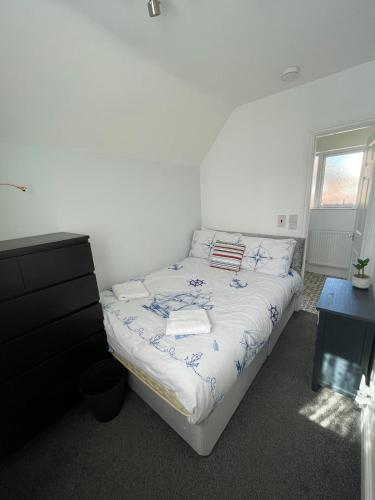 a bedroom with a bed and a dresser at Huge 6 Bedroom House in Sheringham in Sheringham