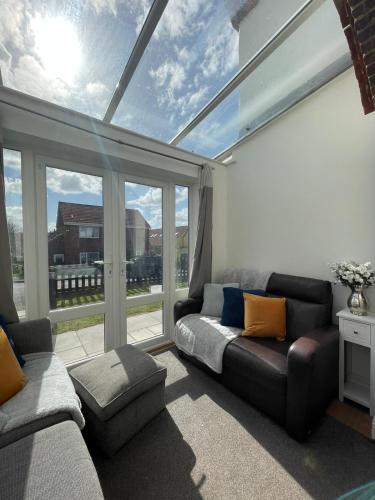 a living room with a couch and a large window at Huge 6 Bedroom House in Sheringham in Sheringham