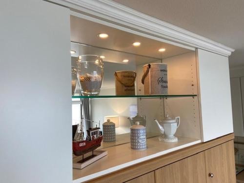 a shelf with vases and other items on it at Top - Seaside Appartement mit Meerblick in Timmendorfer Strand
