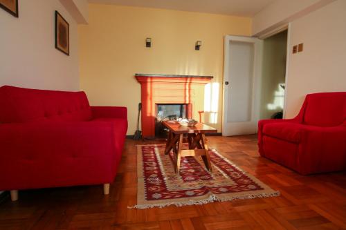a living room with two red couches and a table at Departamento en Viña del mar in Viña del Mar