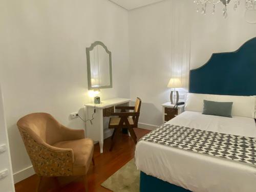 um quarto com uma cama, uma cadeira e uma secretária em Hotel Derby Sevilla em Sevilha