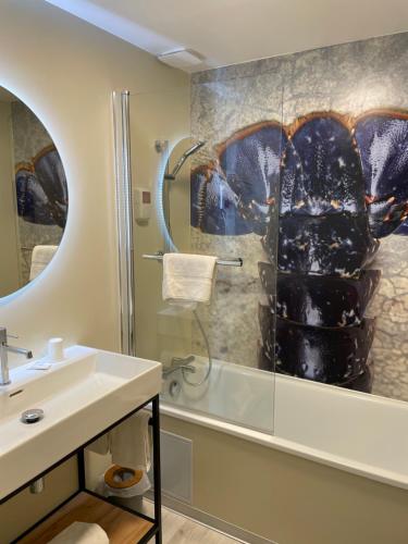 a bathroom with a sink and a shower at La Table De Jeanne in Erquy