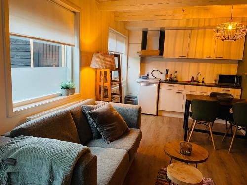 a living room with a couch and a kitchen at Beach House Parallel in Noordwijk
