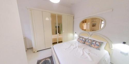 a white room with a bed and a mirror at Stella Maris Marzamemi Apartments in Marzamemi