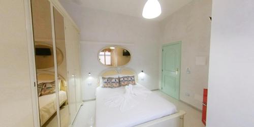 a white room with a bed and a mirror at Stella Maris Marzamemi Apartments in Marzamemi