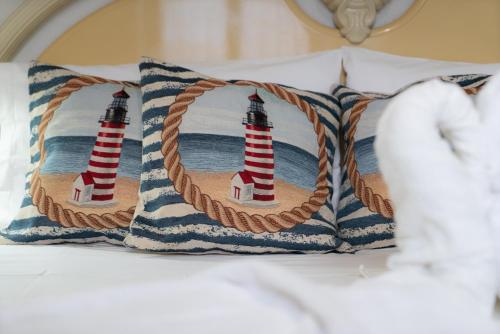 a bed with two lighthouse pillows on it at Stella Maris Marzamemi Apartments in Marzamemi
