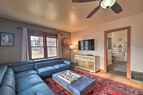 a living room with a blue couch and a ceiling fan at Charming Missoula House Near Downtown and UM! in Missoula