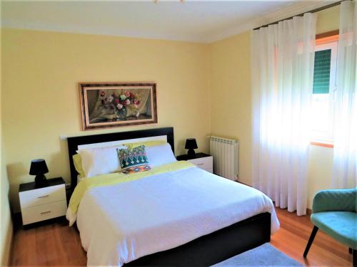 - une chambre avec un grand lit et une fenêtre dans l'établissement Anjos’home, à Viana do Castelo