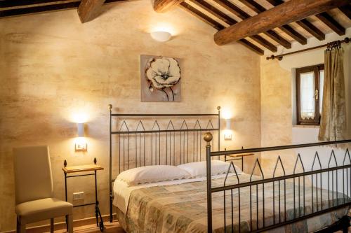 sypialnia z łóżkiem i krzesłem w obiekcie Agriturismo il Cicaleto w mieście Cannara