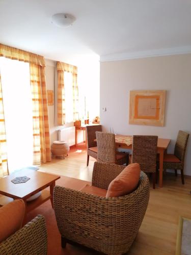 a living room with a couch and chairs and a table at Daniella Apartman in Bükfürdő