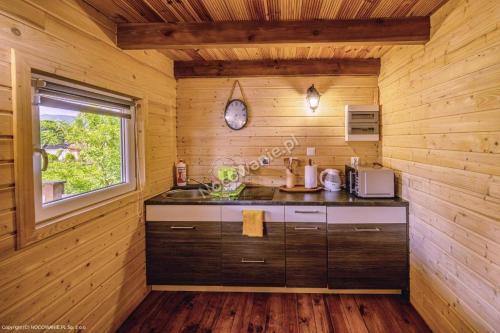 a kitchen with a counter in a wooden cabin at Górska Chatka in Bukowiec
