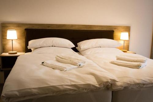 a bed with white sheets and pillows with towels on it at Kolpings-Gästehaus in Haselünne