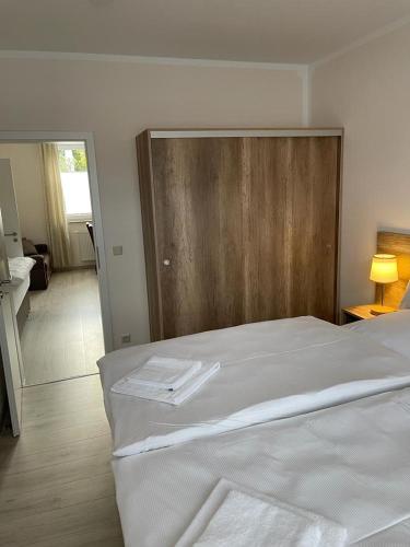 a white bed with a wooden headboard in a room at Kolpings-Gästehaus in Haselünne