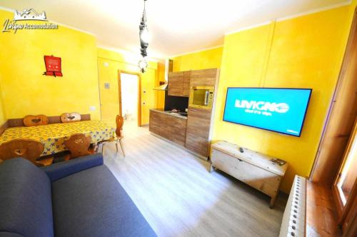 - un salon avec un canapé et une télévision dans l'établissement Residence Casa Longa, à Livigno