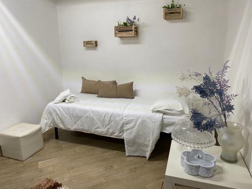 a white room with a bed and a table at “Ad un passo dal mare” in Realmonte