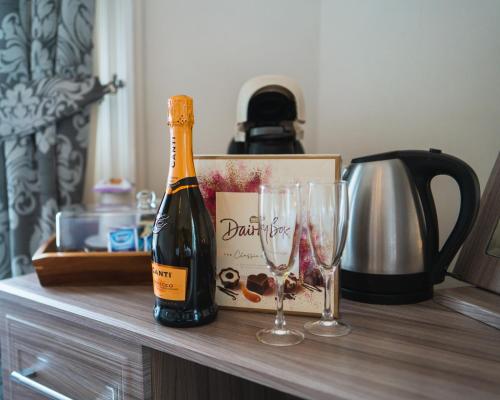 uma garrafa de champanhe e dois copos no balcão em Johnny Dough's Conwy with Rooms em Conwy