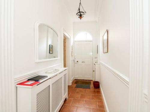 a white bathroom with a sink and a mirror at Magdalene House in Louth