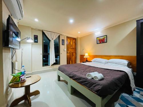 a bedroom with a bed and a table and a television at Aizawl Hotel in Āīzawl