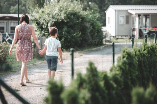 a woman and a child walking down a dirt road at Verblijfpark Ardinam in Olloy-sur-Viroin