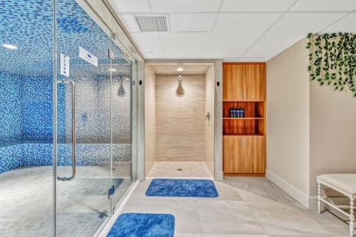 a bathroom with a shower and blue tiles at Oceanfront Suites at Cowichan Bay in Cowichan Bay