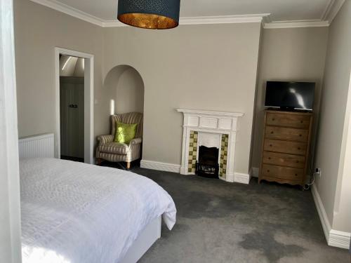a bedroom with a bed and a tv and a fireplace at Stunning 2 Bed Georgian Apartment in Swafield
