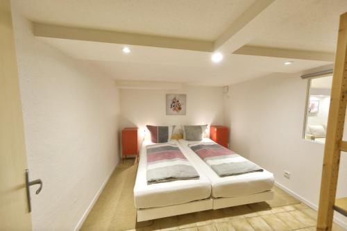um quarto com uma cama num quarto branco em Großzügige und gemütliche 2 Zimmer Ferienwohnung nahe Alz und Chiemsee em Tacherting