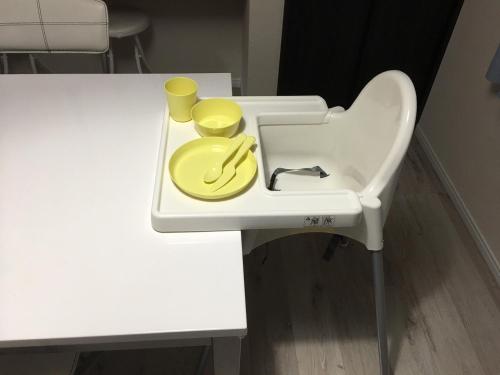 a white sink with two yellow glasses and a plate on it at Nara Guesthouse Kaede in Nara