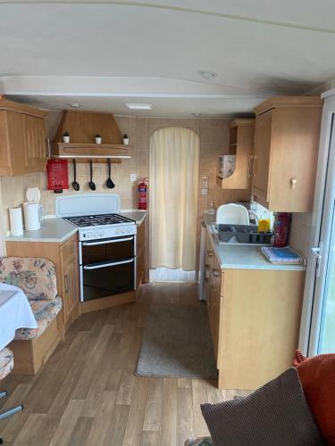 a kitchen with a stove and a sink in a caravan at L&g FAMILY HOLIDAYS 8 BERTH SEALANDS FAMILYS ONLY AND THE LEAD PERSON MUST BE OVER 30 in Ingoldmells