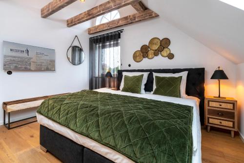 a bedroom with a large bed with a green comforter at Apartment Suite - a57366 in Bad Segeberg
