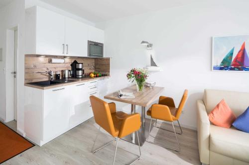 cocina y sala de estar con mesa y sillas en Südpark, en Norderney